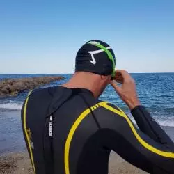 Le bonnet M par Aurélien Magnano - bonnet de piscine de la marque Aurelien Magnano Sur un nageur de triathlon face à la mer